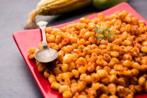 A plate of crispy fried corn, sprinkled with Cajun seasoning and served as a delicious side dish for any meal.